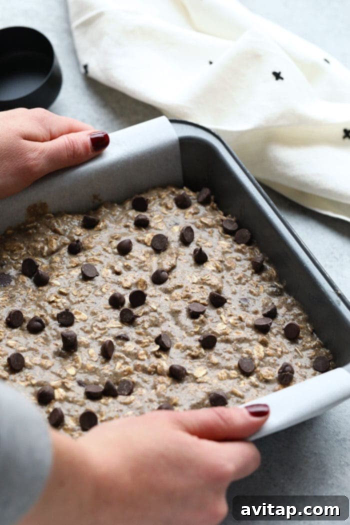 Banana Oatmeal Bars in Baking Pan Freshly baked banana oatmeal bars cooling in a baking pan, ready to be sliced.
