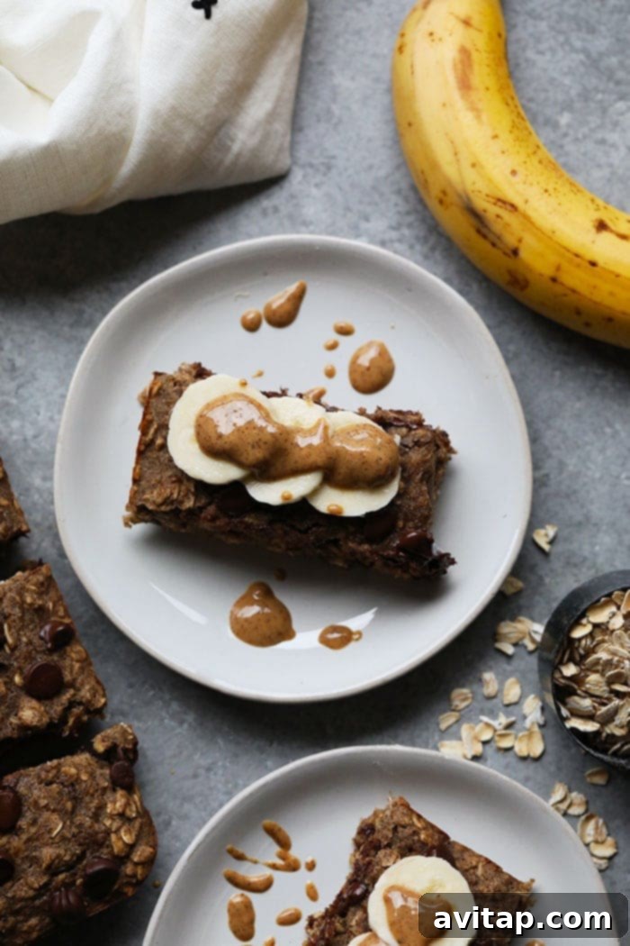 Oatmeal Bars with Banana and Peanut Butter Healthy oatmeal bars topped with fresh banana slices and a drizzle of peanut butter, a perfect combination.
