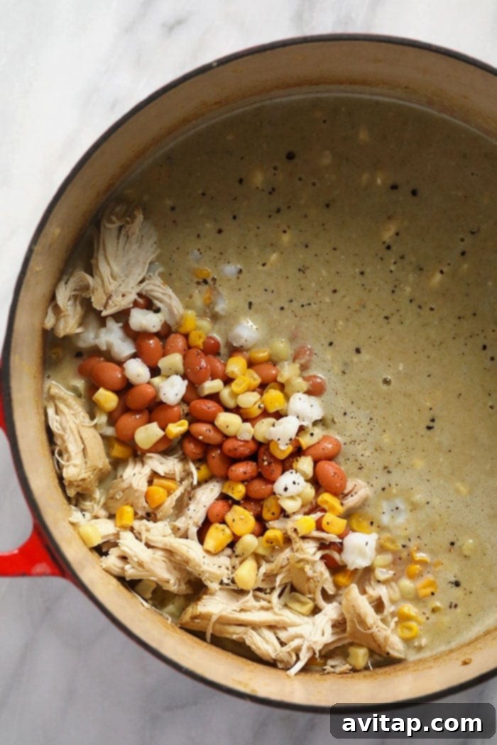 Prepped Ingredients Ready for One-Pot White Bean Chicken Chili All the prepped white bean chicken chili ingredients, including fresh vegetables, canned goods, and spices, gathered in a Dutch oven, ready for cooking.
