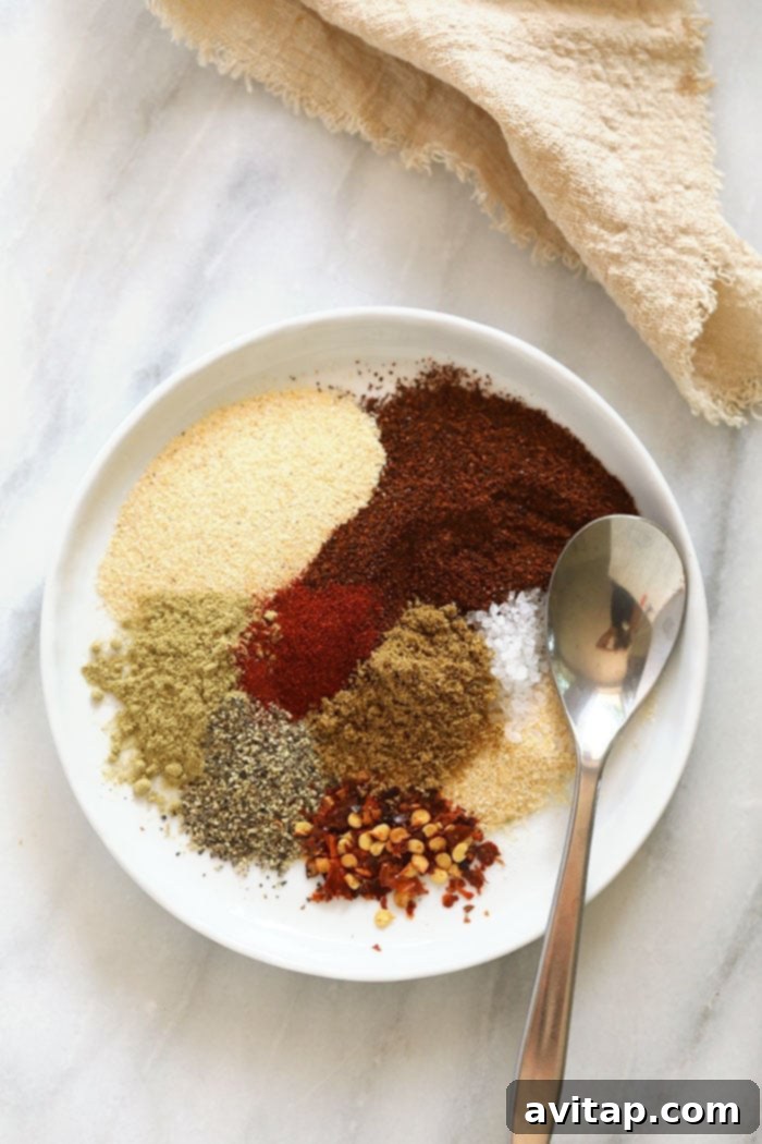 The fresh spices used to create this incredible homemade taco seasoning, ready for blending. Individual ingredients for homemade taco seasoning, beautifully arranged on a white plate.