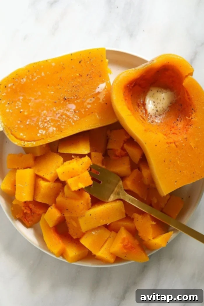 Instant Pot Butternut Squash Recipe 2 Perfectly cooked butternut squash on a plate with butter, salt, and pepper, ready to be enjoyed.
