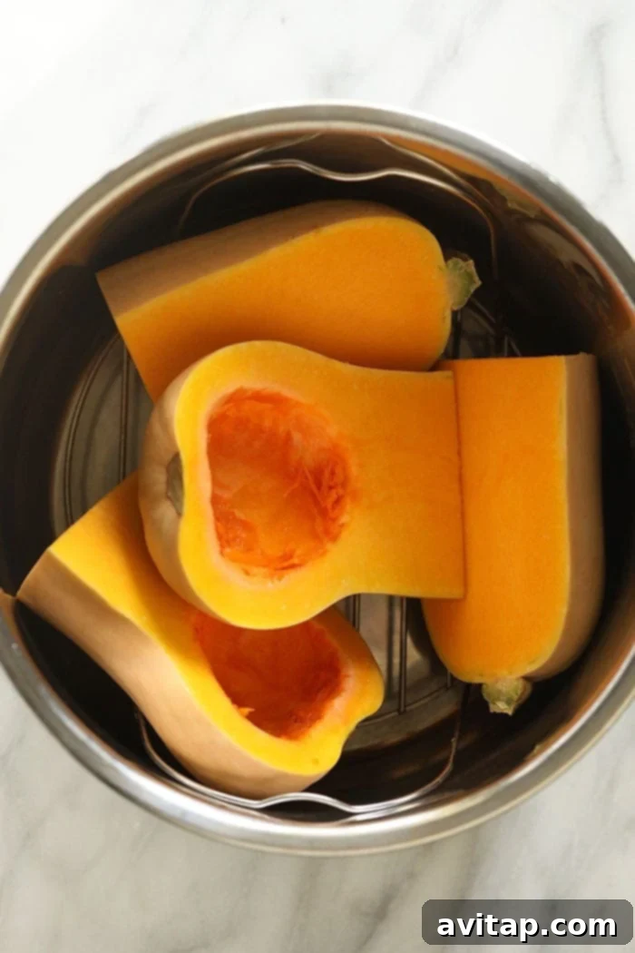Instant Pot Butternut Squash Recipe 6 Butternut squash halves resting on an Instant Pot trivet, surrounded by water.