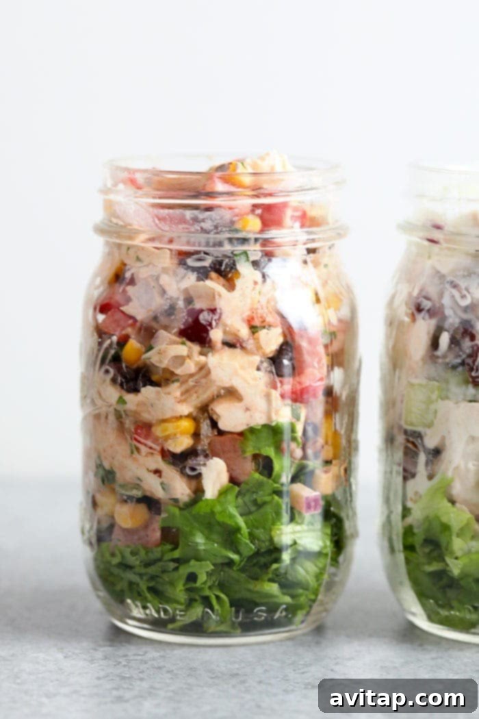 A mason jar layered with romaine lettuce and Southwest Chicken Salad, perfect for a portable meal.