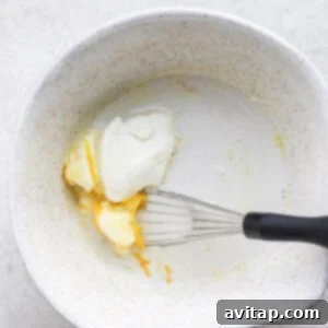 Wet ingredients for pancakes being whisked in a bowl.