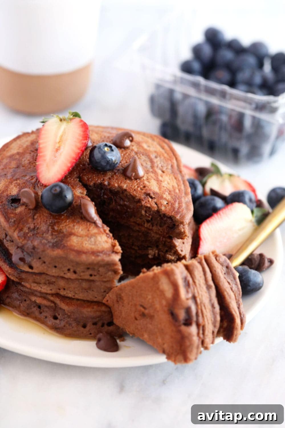 Stack of Healthy Chocolate Chocolate Chip Pancakes with Berries Three healthy chocolate chocolate chip pancakes stacked on a plate with fresh berries