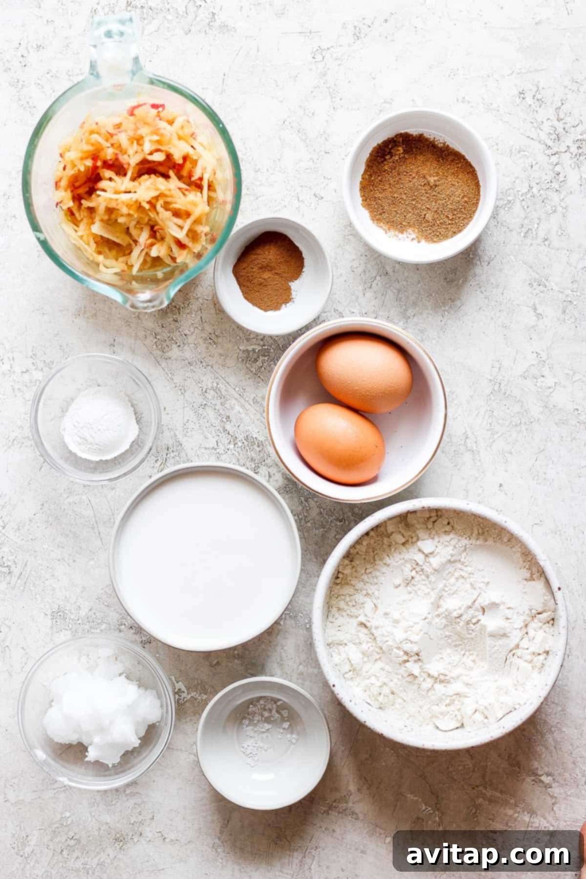 Fresh eggs, all-purpose flour, coconut sugar, and other key ingredients for apple pancakes laid out on a rustic wooden table.