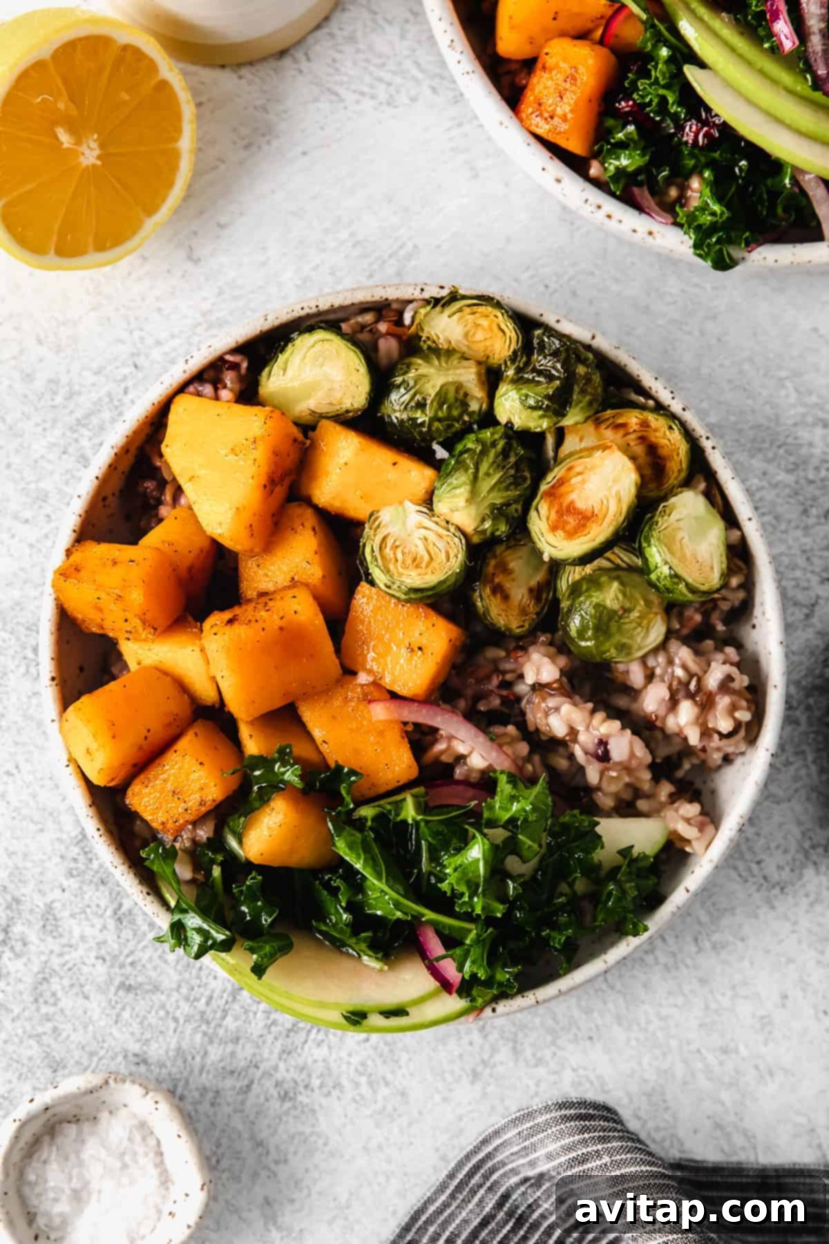 A beautifully arranged Butternut Squash Harvest Bowl with roasted vegetables, wild rice, and kale apple slaw.