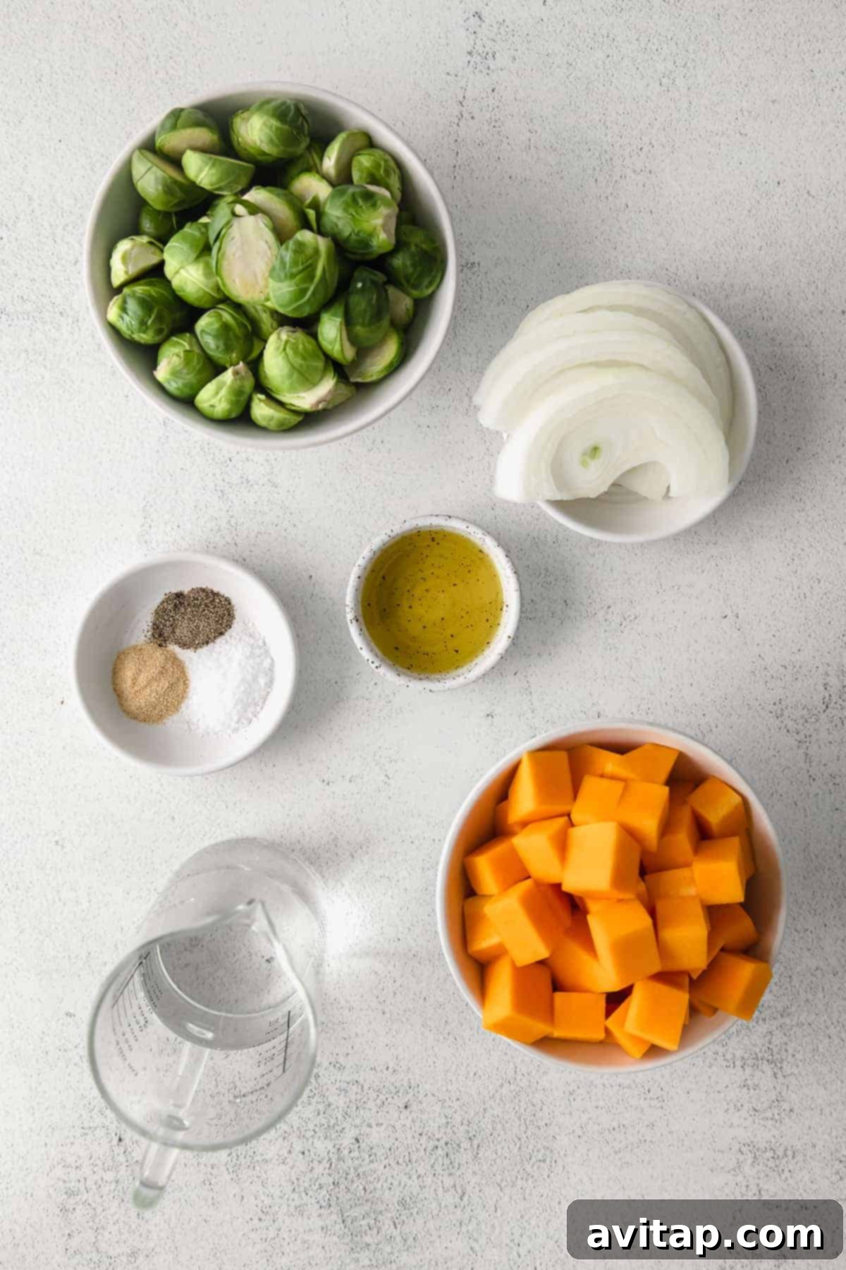 A collection of fresh ingredients for a harvest bowl laid out on a kitchen counter.