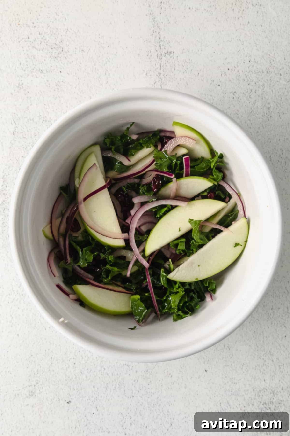 A fresh and vibrant kale and apple slaw in a bowl.