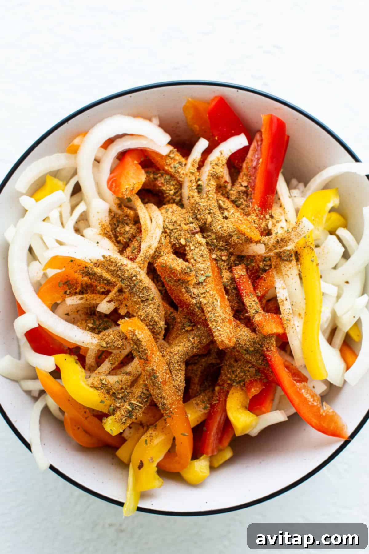 A bowl filled with peppers and onions.