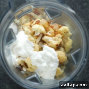 Roasted cauliflower, garlic, and onion added to a blender with broth, sour cream, Greek yogurt, and butter.