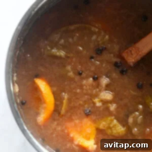 Easy Instant Pot Apple Cider 4 Mashed apples, oranges, and spices in the Instant Pot, forming a pulpy mixture.