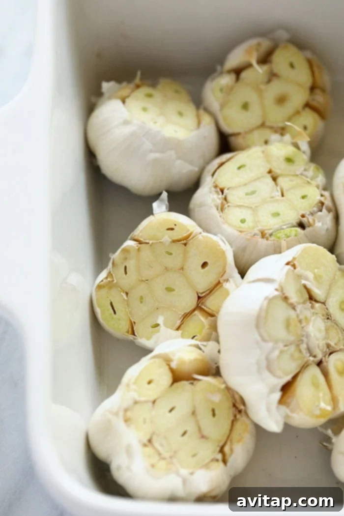 A bowl of freshly roasted garlic bulbs, golden-brown and fragrant, waiting to be enjoyed.