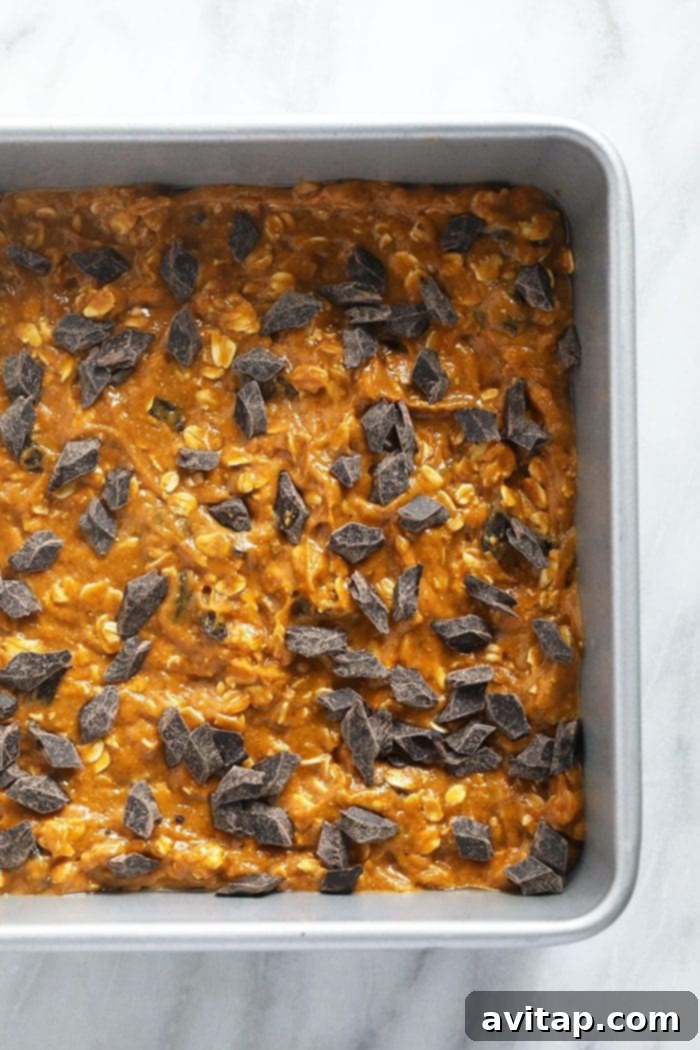 Pumpkin oatmeal bar batter evenly spread in a baking dish, ready for the oven.
