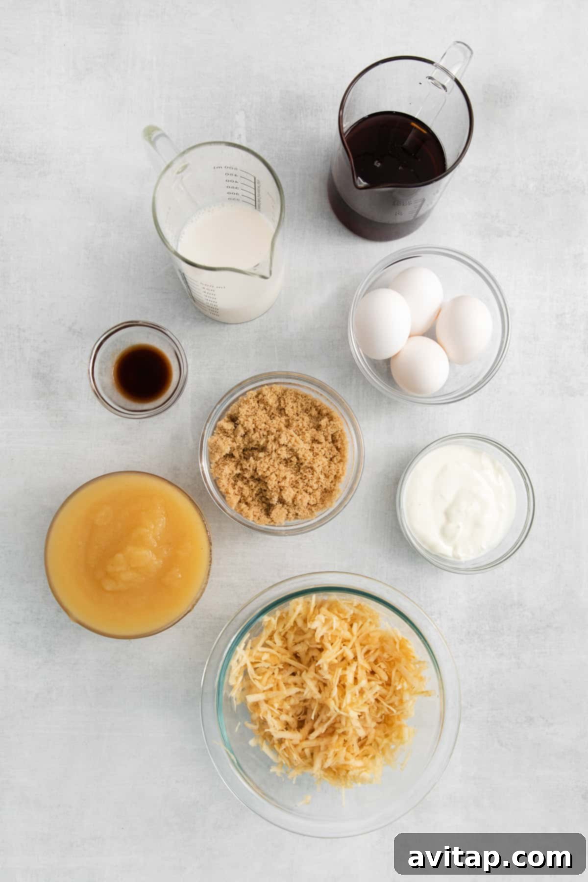 Various ingredients for apple cake displayed in small bowls.