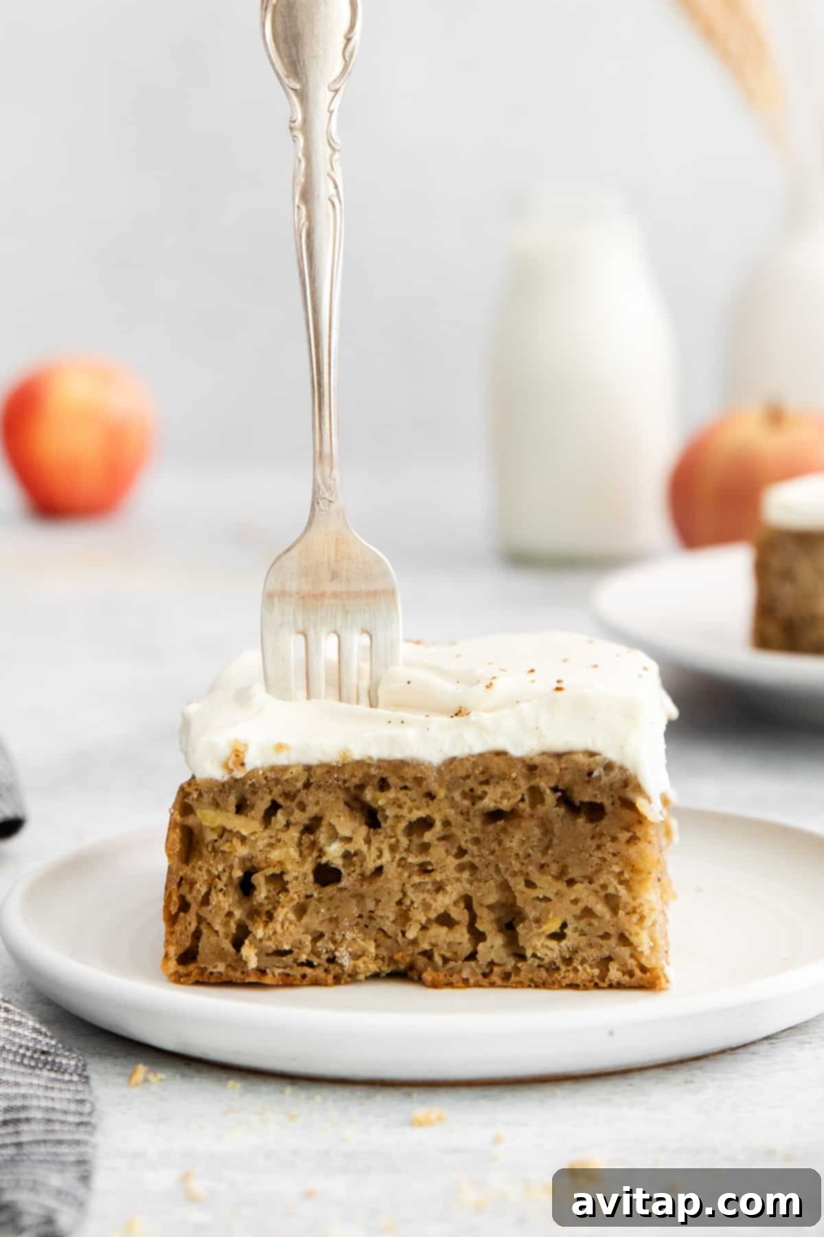 A piece of apple cake with a fork, ready to be enjoyed.