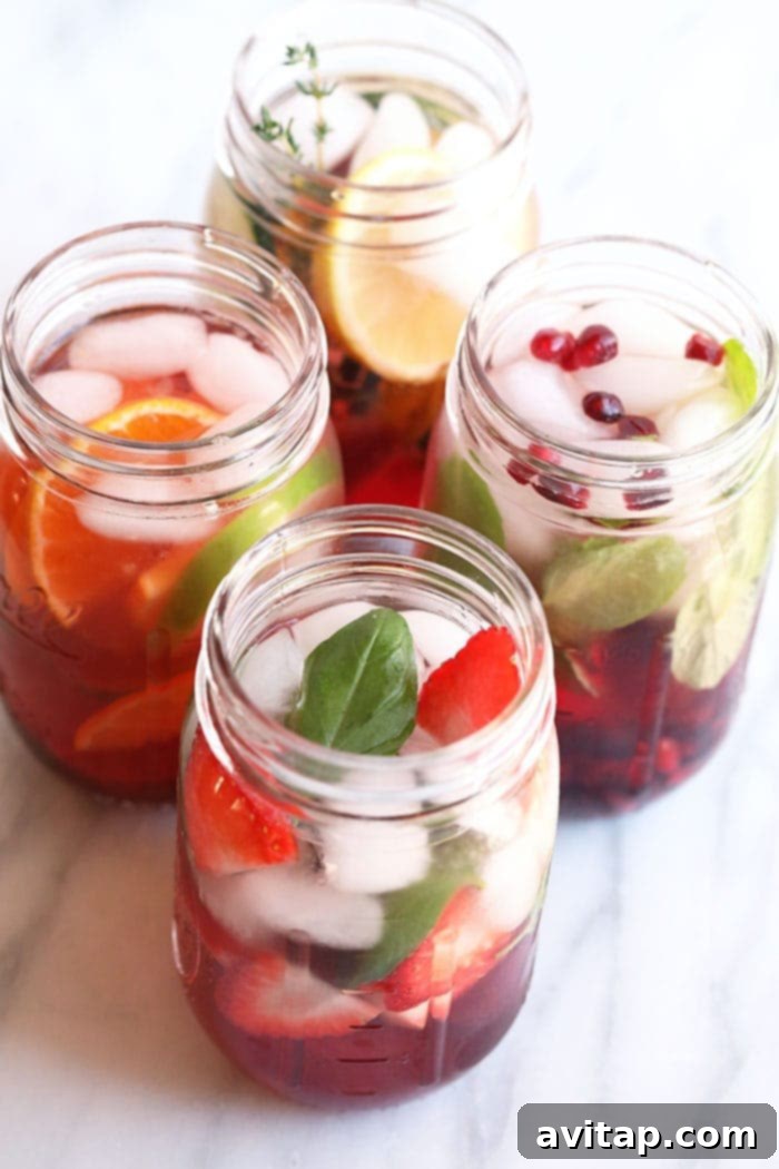Four mason jars filled with colorful fruit-infused waters, featuring various fruits and herbs.
