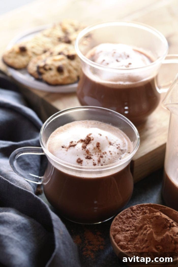 A mug of creamy dairy-free spiked hot chocolate, topped with whipped cream and a sprinkle of cocoa.