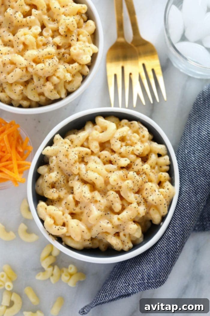 A vibrant bowl of creamy mac and cheese, perfectly golden and garnished with fresh parsley.