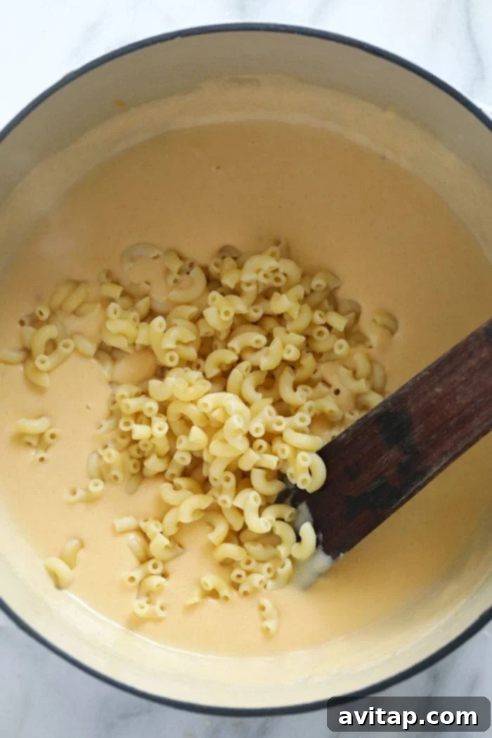 A large Dutch oven filled with rich, golden mac and cheese, ready to be served.