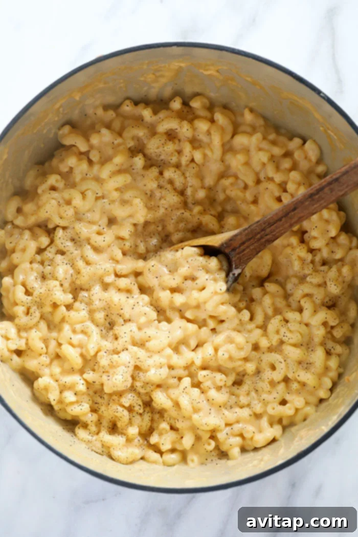 Close-up shot of creamy, perfectly coated mac and cheese in a pot, showcasing its inviting texture.