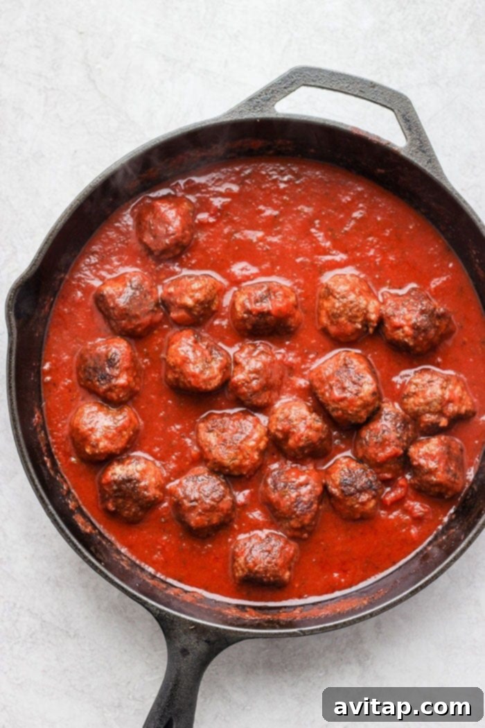 Italian Beef Meatballs in marinara sauce make a delightful and kid-friendly dinner idea. Juicy beef meatballs simmering in a rich marinara sauce in a skillet.