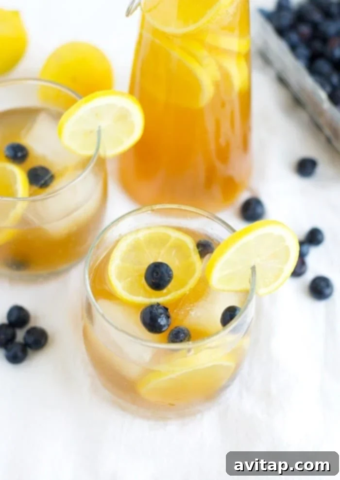 A glass of homemade Kombucha Lemonade with ice and a lemon slice, promising refreshment and natural goodness.