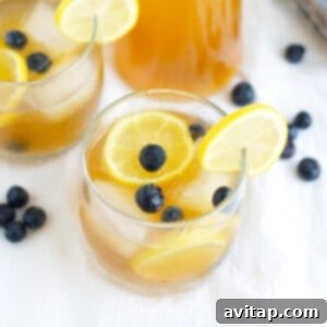 Glasses of refreshing Kombucha Lemonade with blueberries and ice.