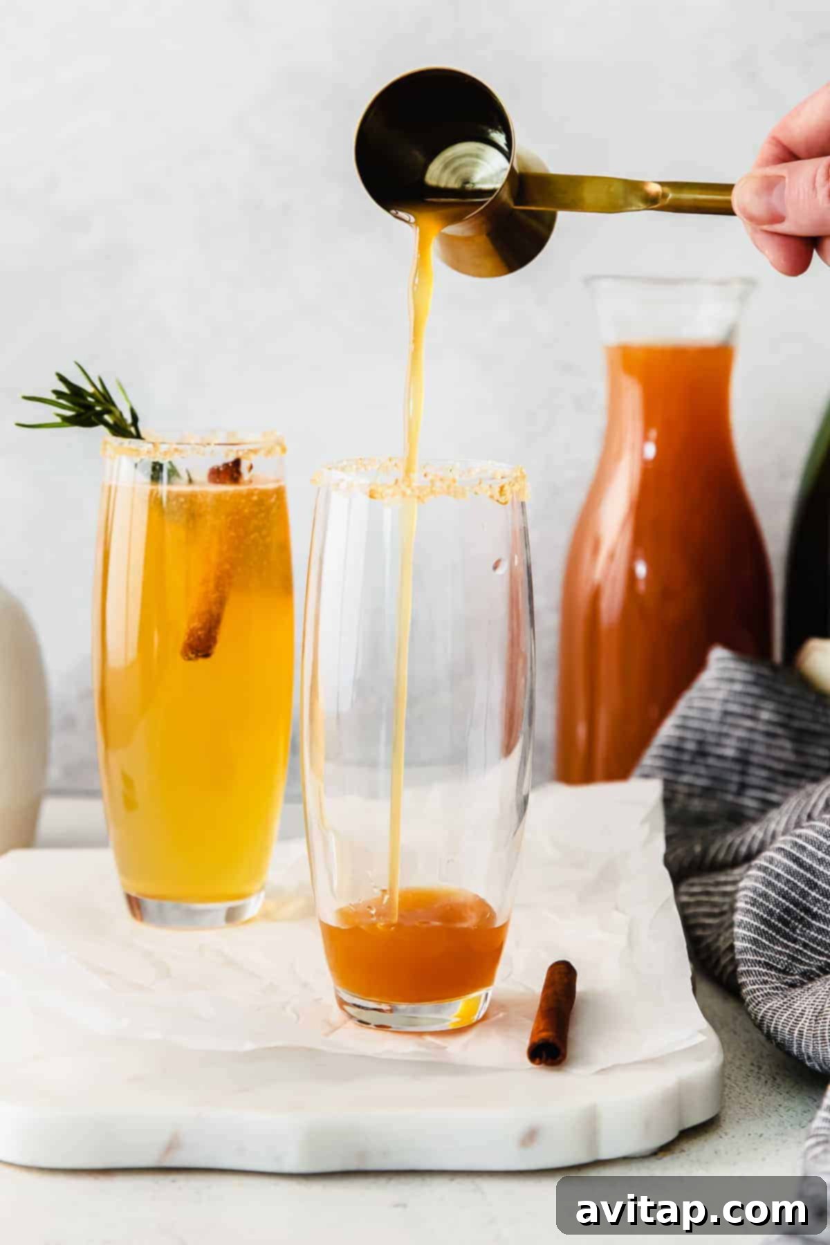 Autumn Apple Mimosa 5 An Apple Cider Mimosa being poured into a cinnamon-sugar rimmed glass.