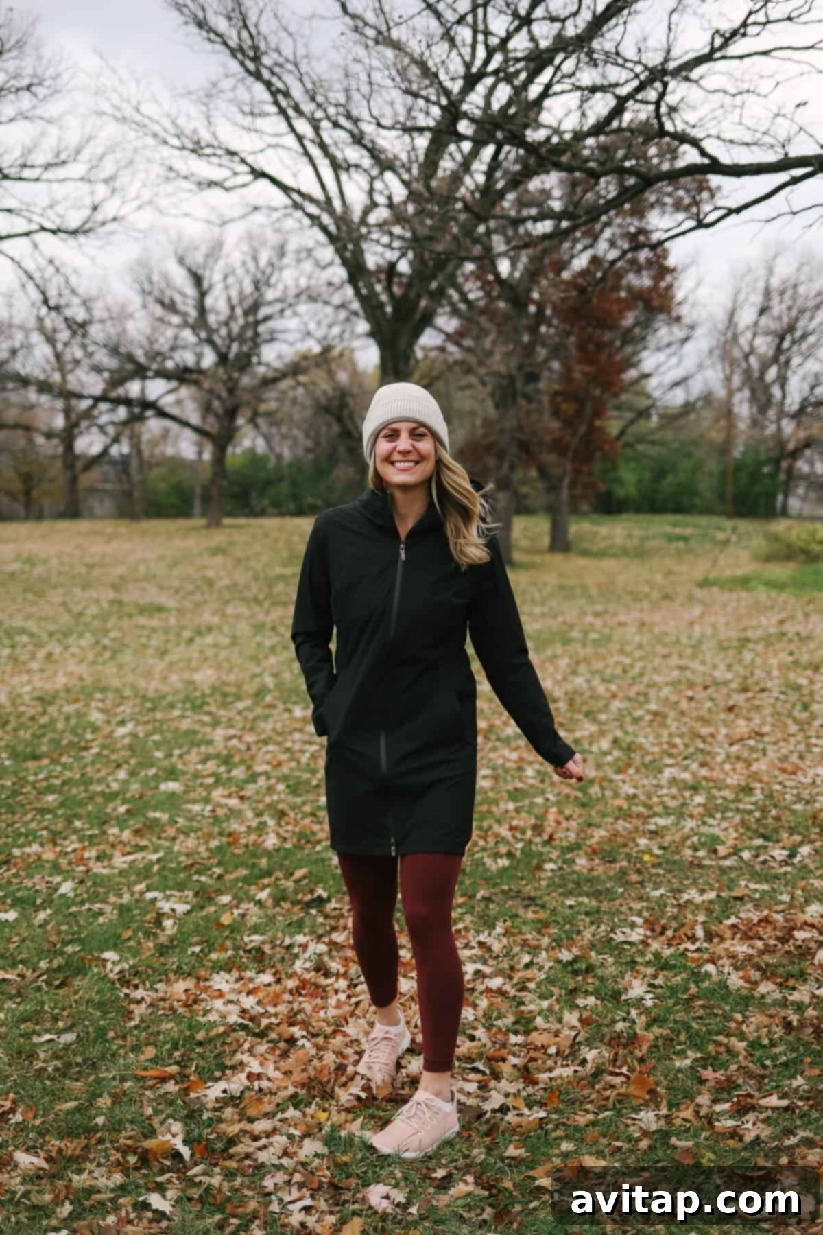 A woman looking chic in a black Lululemon Rain Rebel Jacket and a cozy stocking hat.
