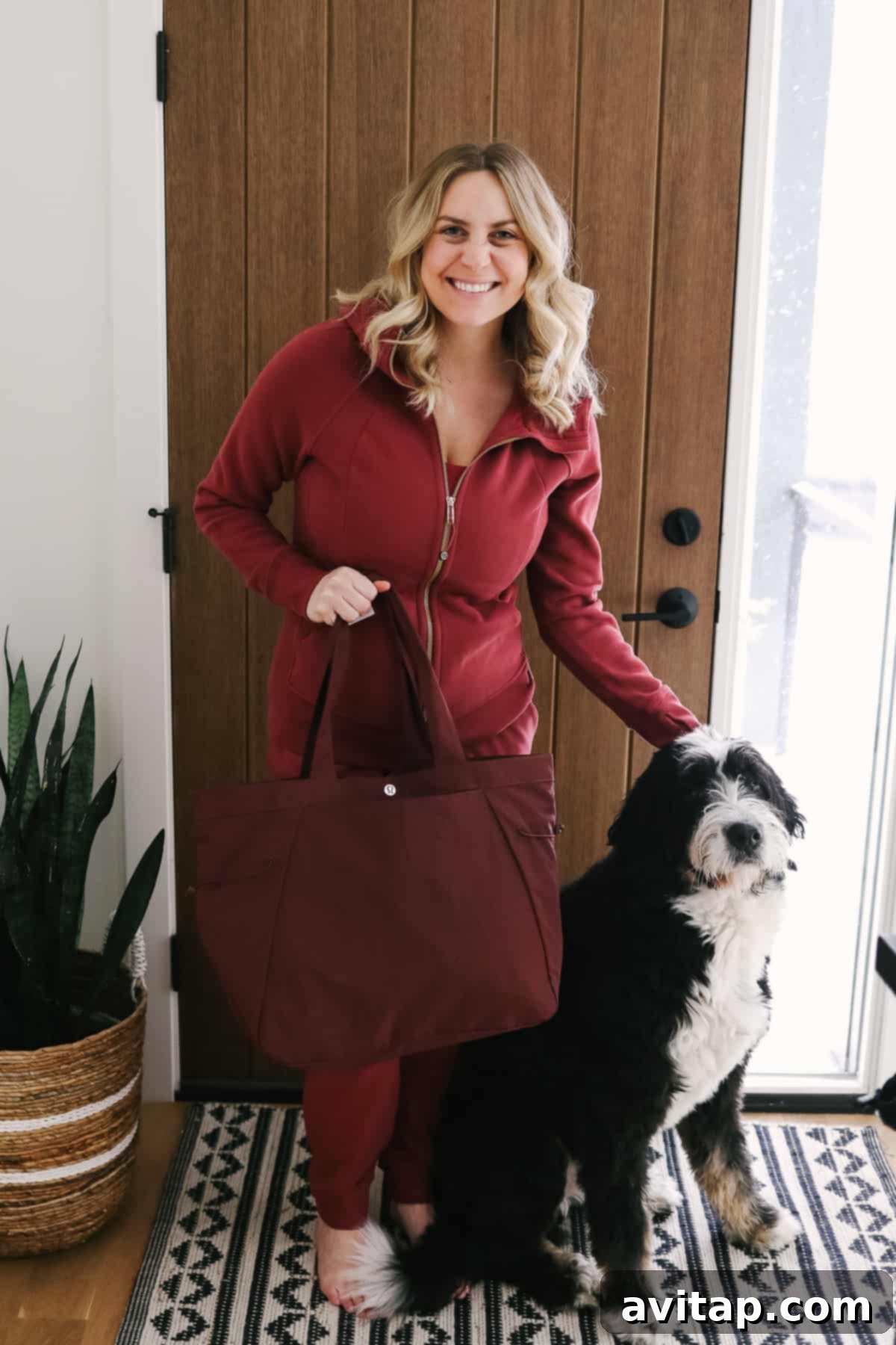 A stylish woman carrying a Lululemon Side Cinch Shopper Bag, standing next to a friendly dog, highlighting everyday versatility.