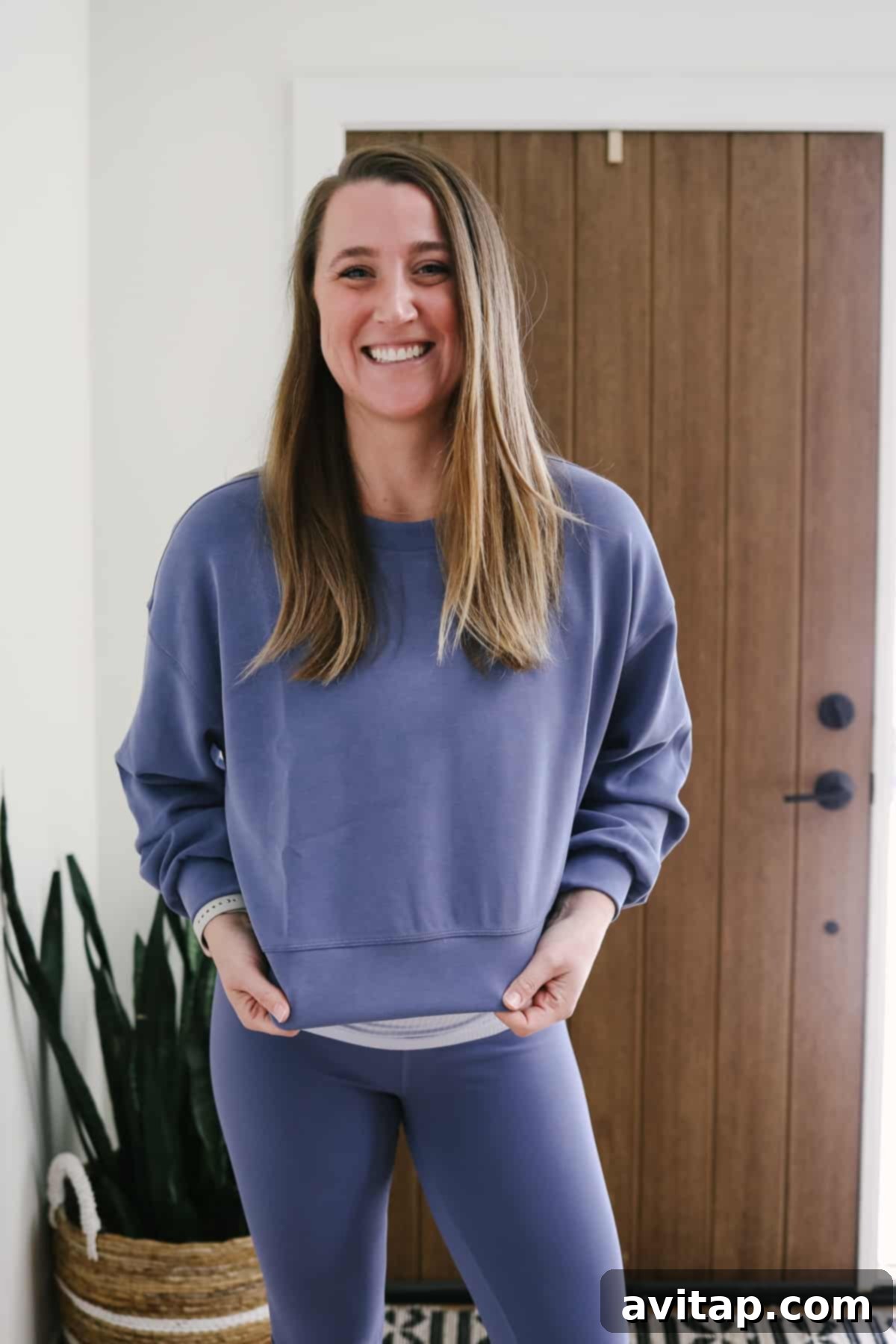 A woman looking relaxed and happy in a Lululemon periwinkle oversized crop crew sweatshirt.