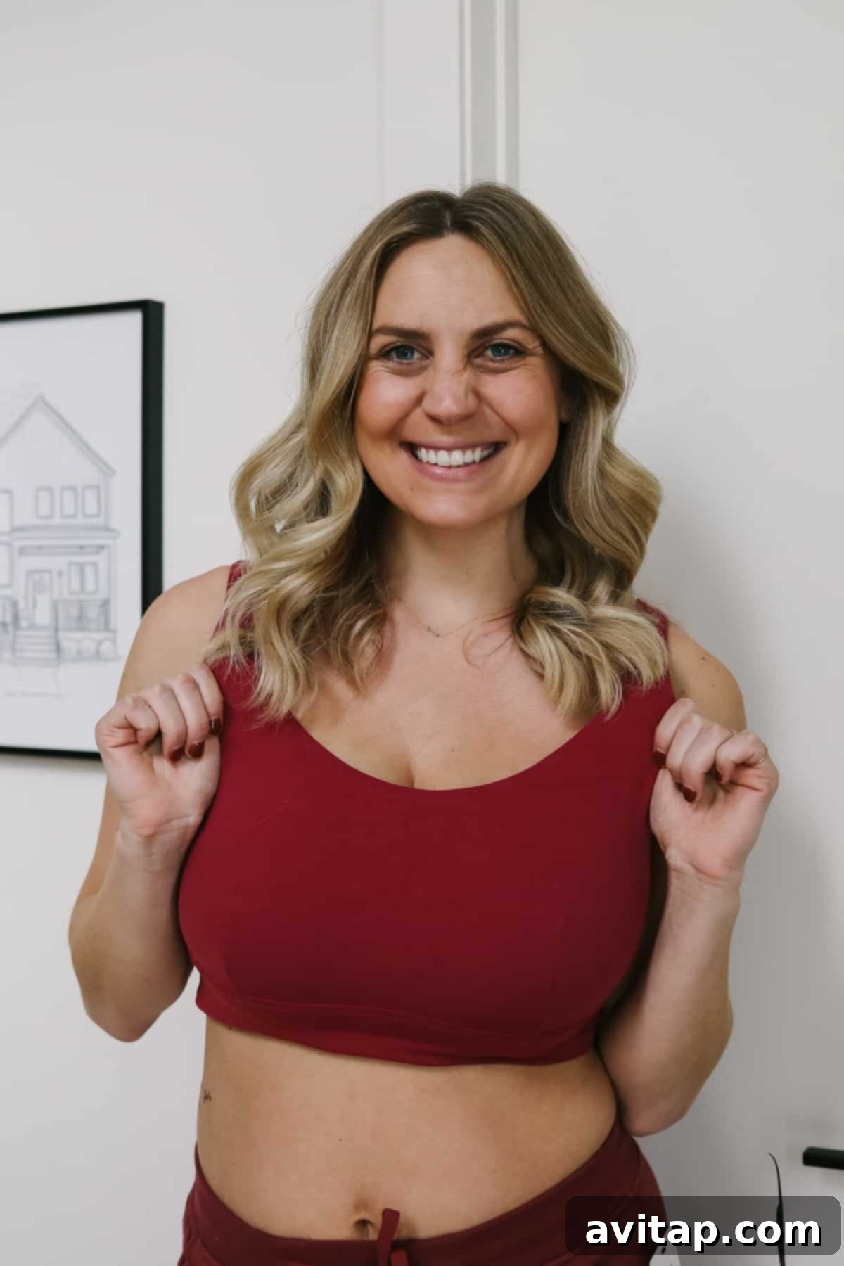 A woman confidently posing in a vibrant red Lululemon Align Reversible Bra during a workout.