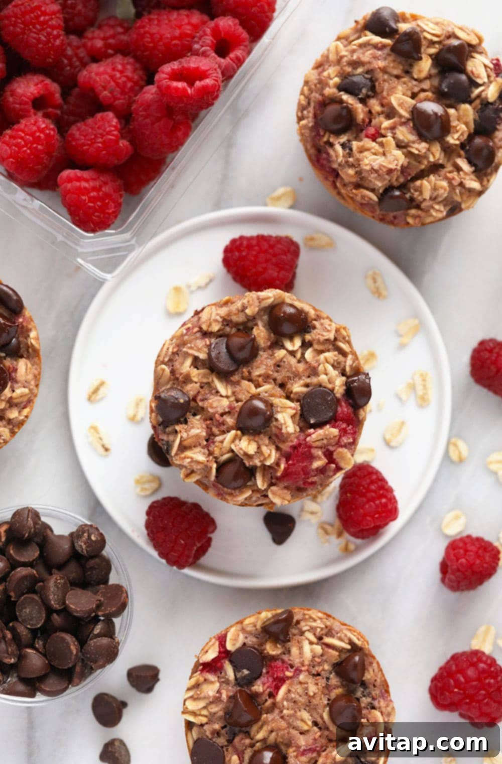 Raspberry Chocolate Chip Baked Oatmeal Cups: Healthy & Delicious Beautifully arranged baked oatmeal cups with raspberries and chocolate chips on a plate