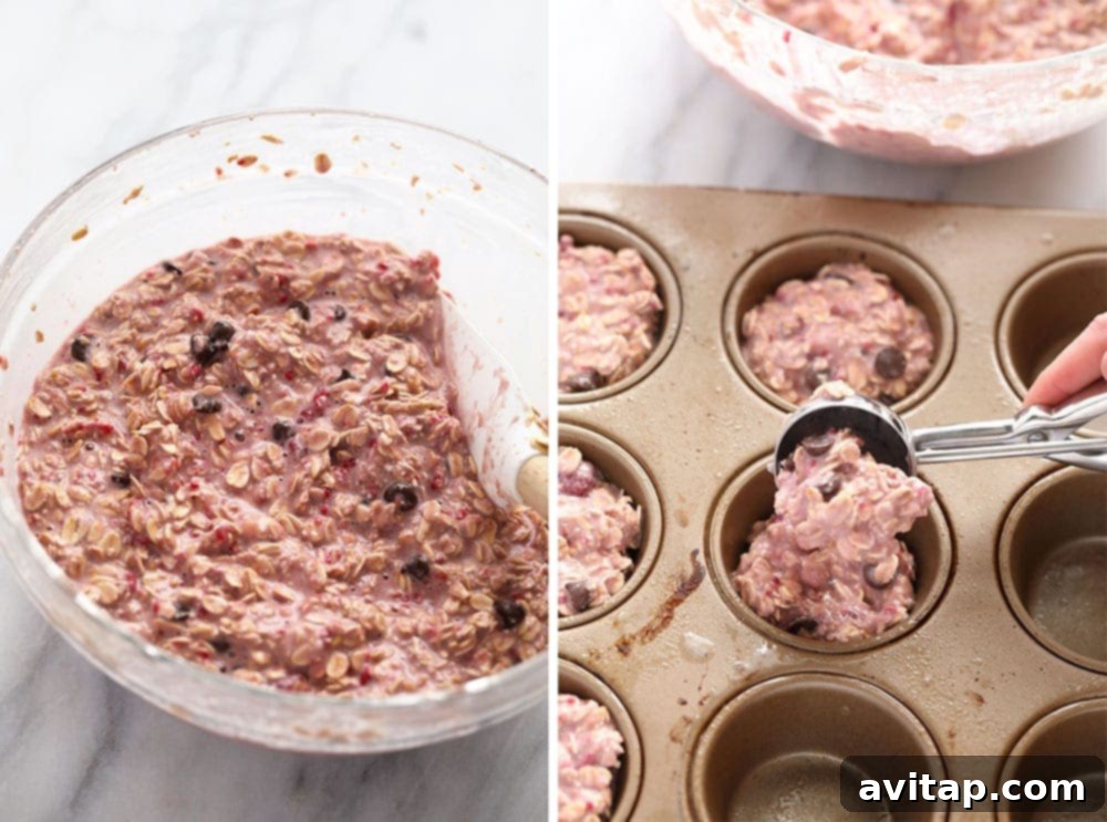 Preparing Baked Oatmeal Cup Batter Oatmeal batter mixed with raspberries and chocolate chips in a bowl, next to a muffin tin
