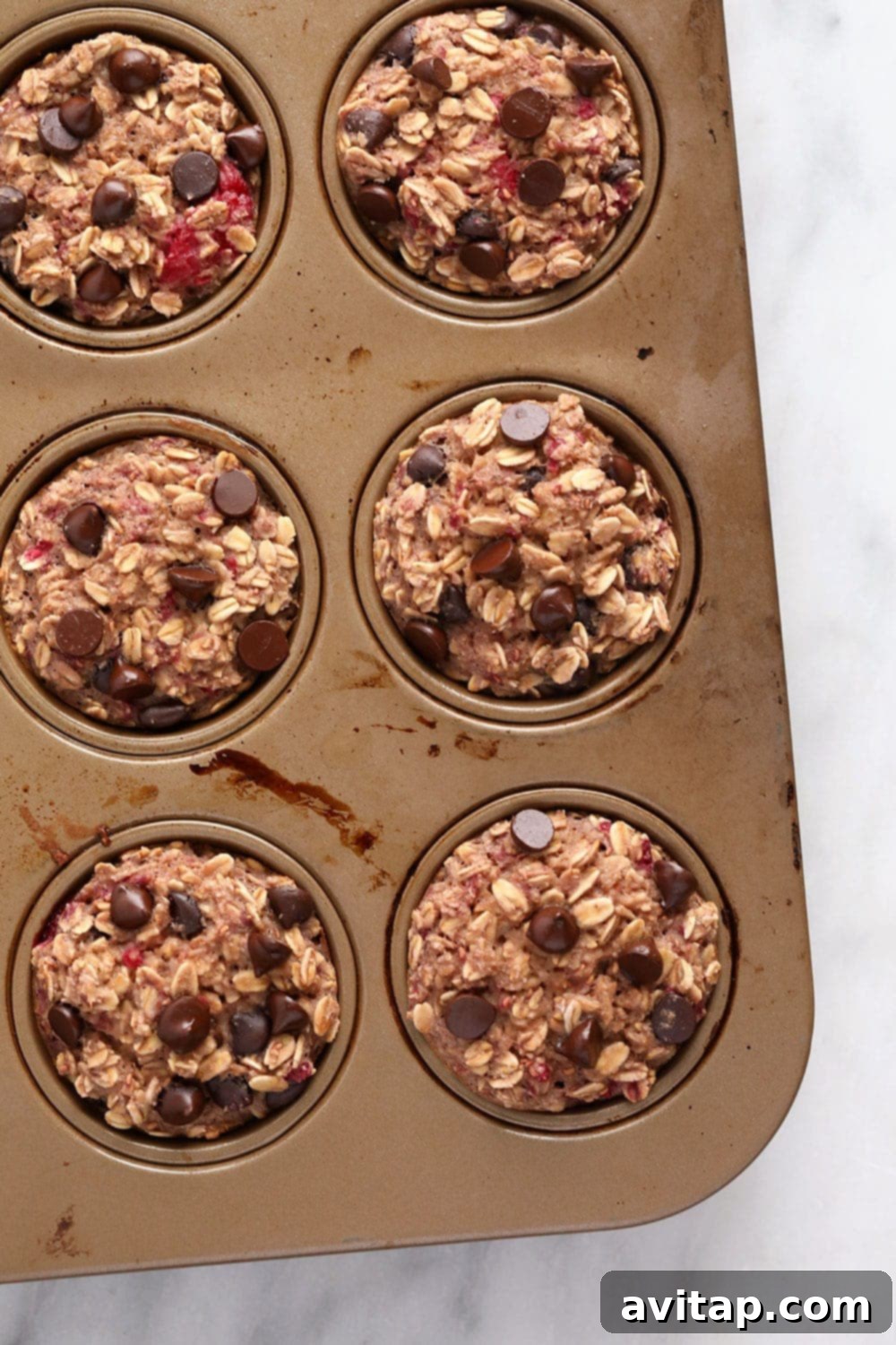 Raspberry Chocolate Chip Oatmeal Muffins 2 Freshly baked raspberry chocolate chip oatmeal cups in a muffin tin
