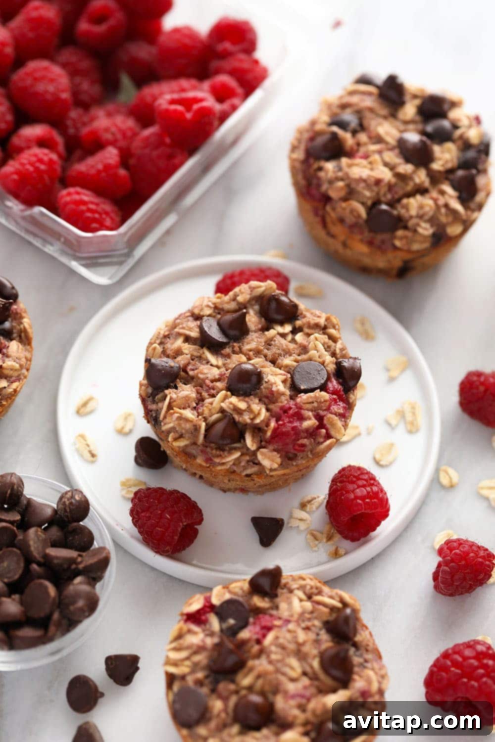 Single Baked Oatmeal Cup Serving Single baked oatmeal cup on a white plate with fresh raspberries