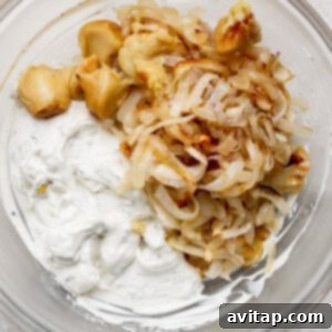 A bowl contains the harmonized blend of roasted garlic, golden caramelized onions, and the herb-infused creamy dip base, perfectly mixed and ready to serve.