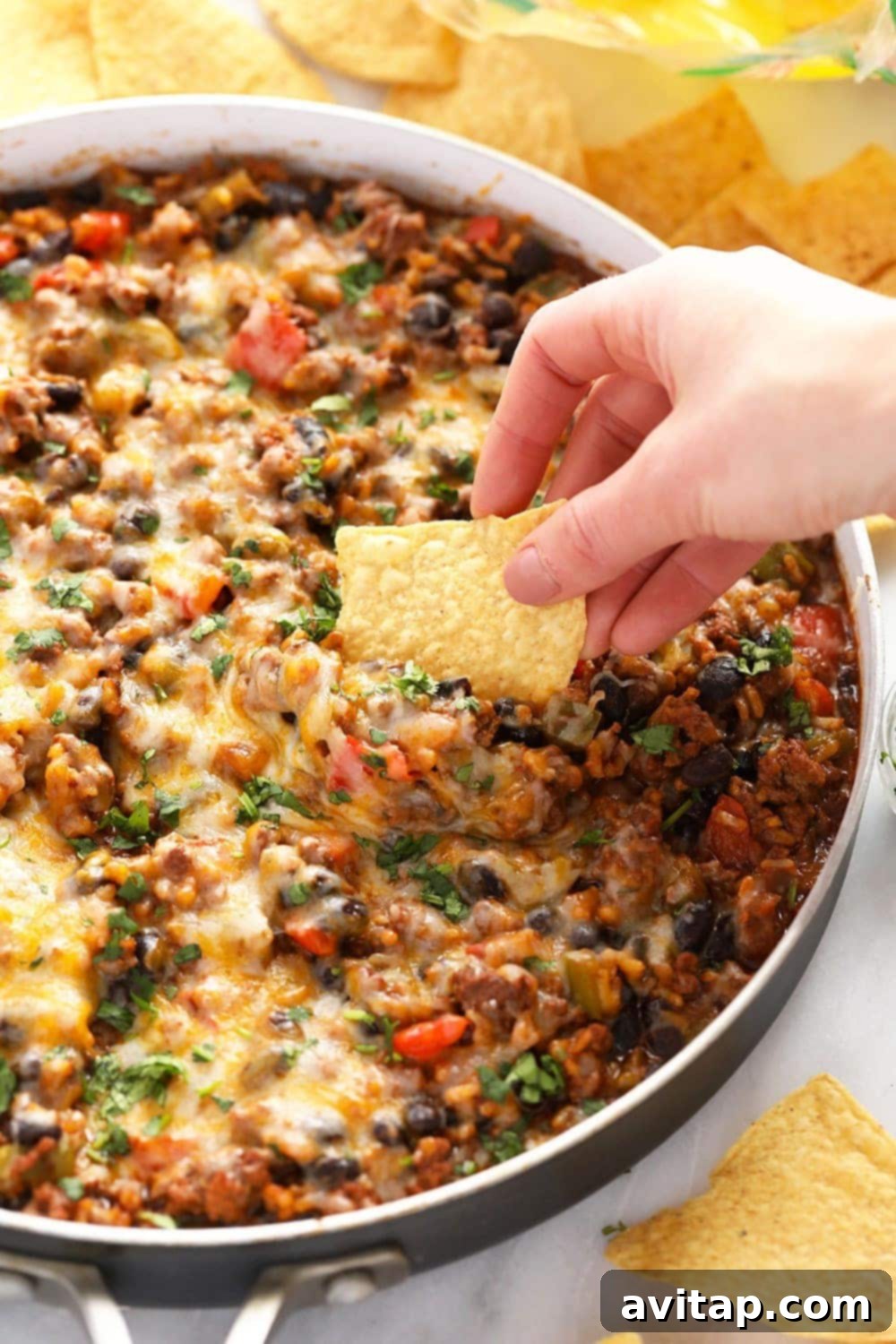 An overhead shot of the finished Mexican ground beef skillet, still in the pan, garnished with fresh cilantro and lime wedges.