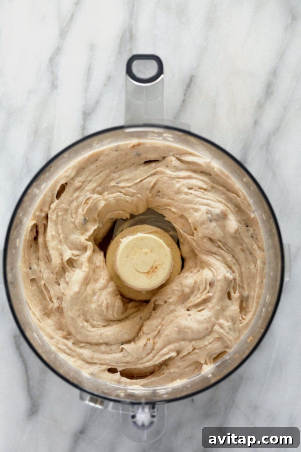 Vegan banana soft serve being processed in a food processor, showing its creamy texture.