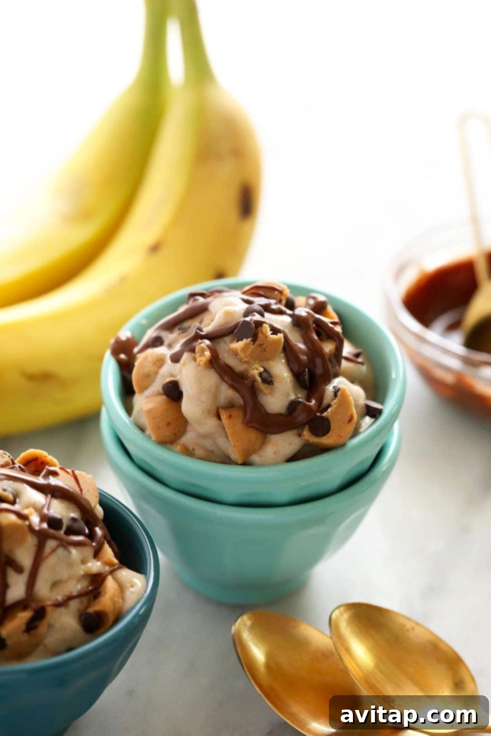 Several bowls of vegan cookie dough banana nice cream, beautifully garnished and ready to be enjoyed.