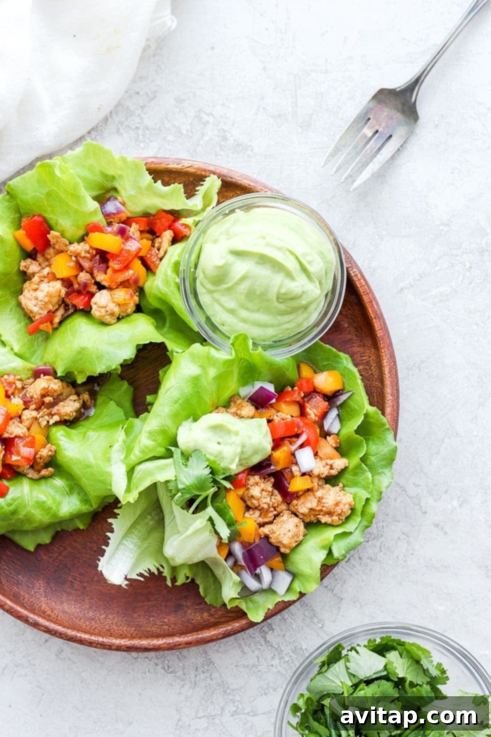 Fajita ground turkey lettuce wraps on a platter, garnished with fresh cilantro and lime