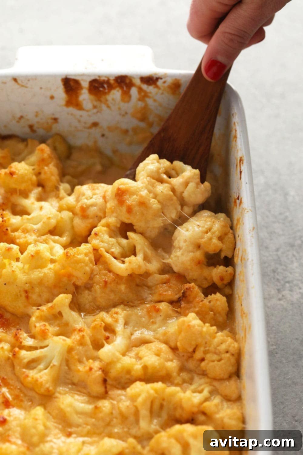 Ultimate Triple Cheese Cauliflower Mac 2 Creamy three cheese cauliflower mac and cheese baking in a casserole dish, topped with golden-brown cheese.
