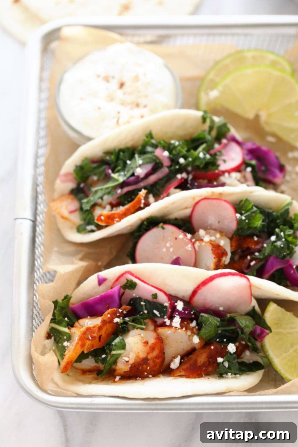 Flavorful baked fish tacos with fresh toppings served in a rustic basket, ready to eat.