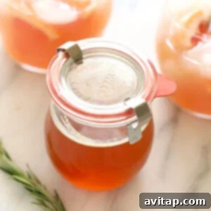 A jar of homemade honey simple syrup on a rustic wooden surface.