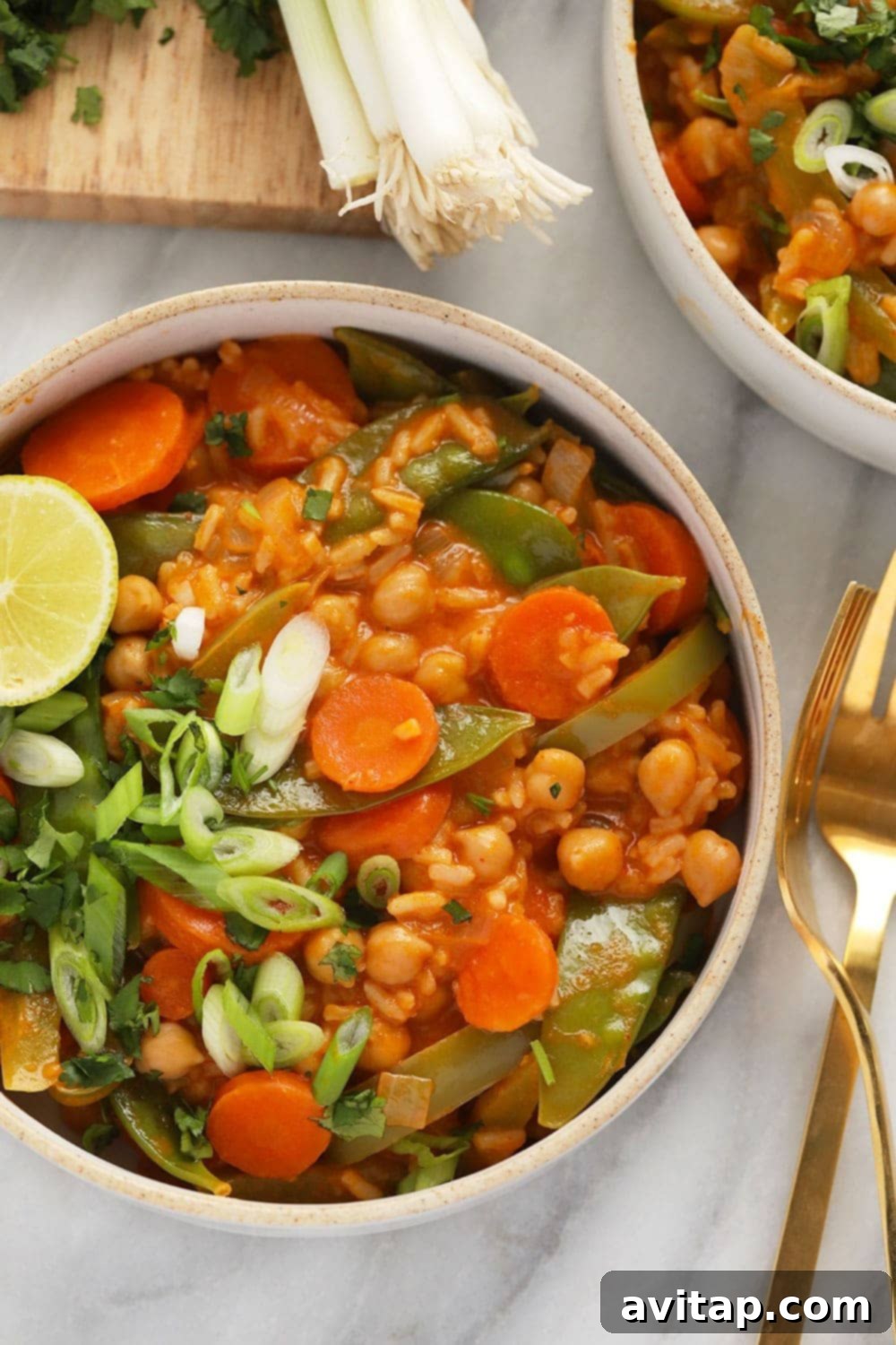 A close-up of a serving of One Pot Vegetarian Thai Curry in a bowl with a fork, garnished with fresh cilantro.