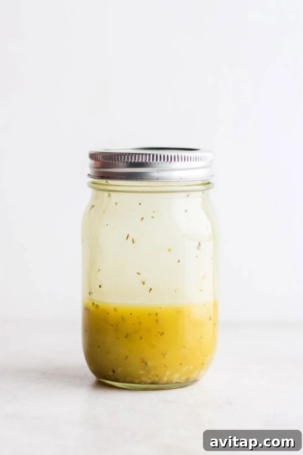 A jar of homemade Greek salad dressing ready to be used