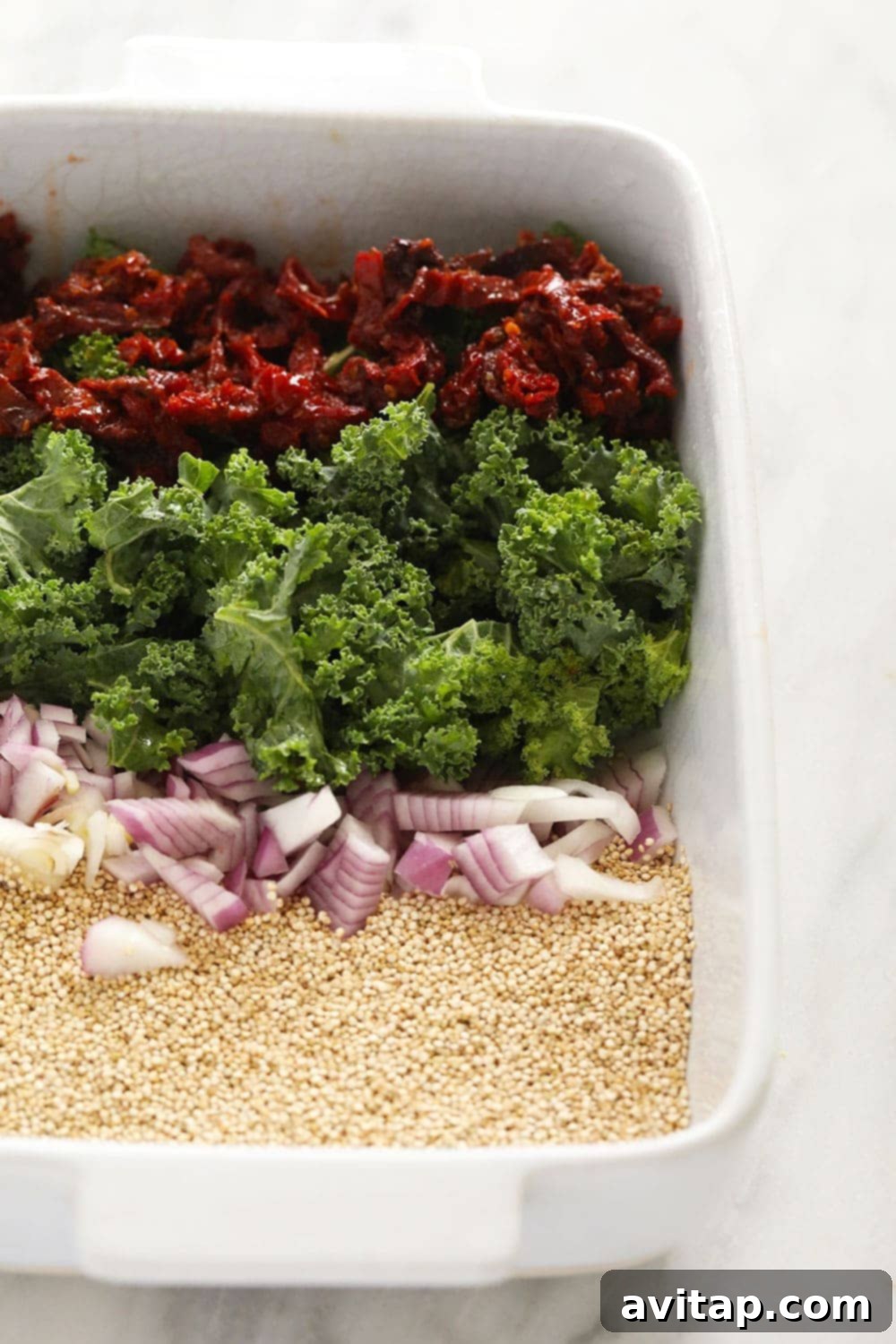 Fresh ingredients for Italian Chicken Sausage Quinoa Casserole laid out in a baking dish before cooking.