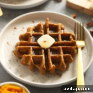 Delicious pumpkin waffle with butter on plate, golden brown and fluffy.