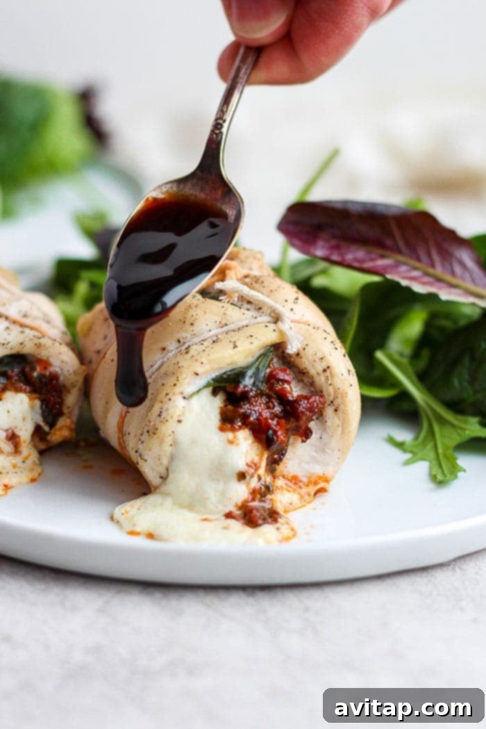 Finished Caprese stuffed chicken breast, beautifully plated and drizzled with a rich balsamic glaze.